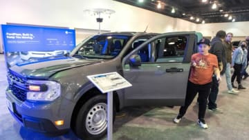 People check out the 2022 Ford Maverick Hybrid during the 2022 Greater Milwaukee International Car & Truck Show at the Wisconsin Center in Milwaukee on Sunday, Feb. 27, 2022. The show continues through March 6, and features about 400 new cars and trucks from a diverse set of brands.Wild Autoshow 0398