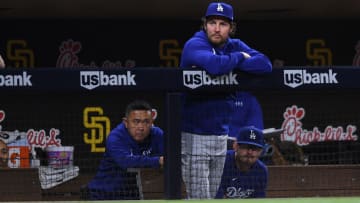 Jun 22, 2021; San Diego, California, USA; Los Angeles Dodgers starting pitcher Trevor Bauer (top) looks on from the dugout during the fifth inning against the San Diego Padres at Petco Park. Mandatory Credit: Orlando Ramirez-USA TODAY Sports