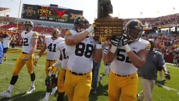 AMES, IA - SEPTEMBER 9: Defensive lineman Jake Hulett #88 of the Iowa Hawkeyes, and offensive lineman Boone Myers #52 of the Iowa Hawkeyes celebrate with teammates by carrying the Cy-Hawk Trophy off the field after defeating the Iowa State Cyclones 44-41 in overtime at Jack Trice Stadium on September 9, 2017 in Ames, Iowa. The Iowa Hawkeyes won 44-41 over the Iowa State Cyclones. (Photo by David Purdy/Getty Images)