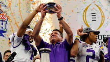 ATLANTA, GEORGIA - DECEMBER 28: Head coach Ed Orgeron of the LSU Tigers holds the Chick-fil-A Peach Bowl trophy on the podium with the team after winning the Chick-fil-A Peach Bowl 28-63 over the Oklahoma Sooners at Mercedes-Benz Stadium on December 28, 2019 in Atlanta, Georgia. (Photo by Kevin C. Cox/Getty Images)