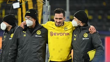 Mats Hummels (C) is helped off injured during the UEFA Champions League group F football match Borussia Dortmund v Lazio (Photo by INA FASSBENDER/AFP via Getty Images)