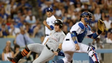 LOS ANGELES, CA - MAY 20: J.T. Realmuto #11 of the Miami Marlins slides past catcher Yasmani Grandal #9 of the Los Angeles Dodgers to score run in the third inning at Dodger Stadium on May 20, 2017 in Los Angeles, California. (Photo by Stephen Dunn/Getty Images)