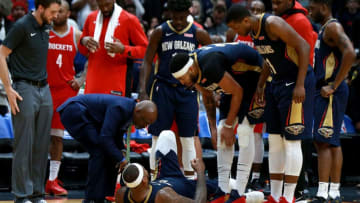 NEW ORLEANS, LA - JANUARY 26: Players stand around DeMarcus Cousins