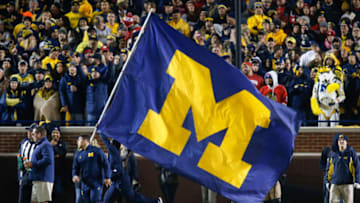 ANN ARBOR, MI - OCTOBER 13: A Michigan cheerleader runs with the Michigan flag across the field after a score during a game between the Wisconsin Badgers (15) and the Michigan Wolverines (12) on October 13, 2018 at Michigan Stadium in Ann Arbor, Michigan. (Photo by Scott W. Grau/Icon Sportswire via Getty Images
