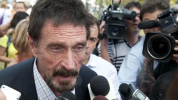 December 13, 2012 - John McAfee talks to the media at the Beacon Hotel where he is staying after arriving last night from Guatemala on December 13, 2012 in Miami Beach, Florida. McAfee is a 'person of interest' in the fatal shooting of his neighbor in Belize and turned up in Guatemala after a month on the run in Belize. (Photo by Michele Eve Sandberg/Corbis via Getty Images)