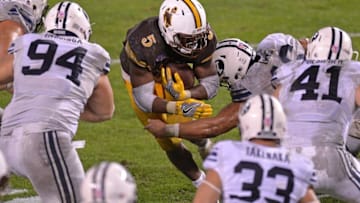 Dec 21, 2016; San Diego, CA, USA; Wyoming Cowboys running back Brian Hill (5) is defended by Brigham Young Cougars defensive end Harvey Langi during the fourth quarterat Qualcomm Stadium. Mandatory Credit: Jake Roth-USA TODAY Sports