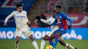 LONDON, ENGLAND - DECEMBER 28: Wilfried Zaha of Crystal Palace and James Justin and Nempalys Mendy of Leicester City in action during the Premier League match between Crystal Palace and Leicester City at Selhurst Park on December 28, 2020 in London, United Kingdom. (Photo by Sebastian Frej/MB Media/Getty Images)