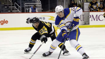 Oct 5, 2021; Pittsburgh, Pennsylvania, USA; Pittsburgh Penguins defenseman Mark Friedman (52) tries to strip the puck from Buffalo Sabres right wing Jack Quinn (22) during the third period at PPG Paints Arena. The Penguins won 5-4 in a shootout. Mandatory Credit: Charles LeClaire-USA TODAY Sports