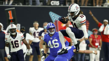 LAS VEGAS, NEVADA - SEPTEMBER 04: Linebacker Drew Jensen #46 of the Brigham Young Cougars looks on as wide receiver Tayvian Cunningham #11 of the Arizona Wildcats leaps over place kicker Justen Smith #37 of the Brigham Young Cougars on a punt return during the Good Sam Vegas Kickoff Classic at Allegiant Stadium on September 4, 2021 in Las Vegas, Nevada. The Cougars defeated the Wildcats 24-16. (Photo by Ethan Miller/Getty Images)