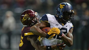 Jan 2, 2016; Phoenix, AZ, USA; West Virginia Mountaineers wide receiver Gary Jennings (12) breaks the tackle of Arizona State Sun Devils defensive back Kareem Orr (25) en route to a touchdown during the second half of the 2016 Cactus Bowl at Chase Field. The Mountaineers won 43-42. Mandatory Credit: Joe Camporeale-USA TODAY Sports