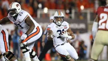 Jan 6, 2014; Pasadena, CA, USA; Auburn Tigers running back Tre Mason (21) carries the ball past the blocking of Greg Robinson (73) against the Florida State Seminoles during the first half of the 2014 BCS National Championship game at the Rose Bowl. Mandatory Credit: Matthew Emmons-USA TODAY Sports