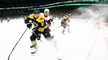 BOSTON, MA - DECEMBER 11: Richard Panik #14 of the Arizona Coyotes and John Moore #27 of the Boston Bruins battle for control of the puck during the second period at TD Garden on December 11, 2018 in Boston, Massachusetts. (Photo by Maddie Meyer/Getty Images)