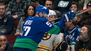 VANCOUVER, BC - FEBRUARY 22: Tyler Myers #57 of the Vancouver Canucks checks Anders Bjork #10 of the Boston Bruins into the side boards during NHL action at Rogers Arena on February 22, 2020 in Vancouver, Canada. (Photo by Rich Lam/Getty Images)