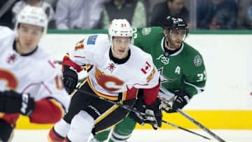 Dec 17, 2015; Dallas, TX, USA; Calgary Flames left wing Mason Raymond (21) and Dallas Stars defenseman Alex Goligoski (33) chase the puck during the third period at the American Airlines Center. Raymond scores a goal. The Flames defeat the Stars 3-1. Mandatory Credit: Jerome Miron-USA TODAY Sports