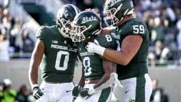 EAST LANSING, MICHIGAN - OCTOBER 15: Keon Coleman #0, Jalen Berger #8 and Nick Samac #59 of the Michigan State Spartans celebrate Bergers touchdown against the Wisconsin Badgers during the first quarter at Spartan Stadium on October 15, 2022 in East Lansing, Michigan. (Photo by Nic Antaya/Getty Images)