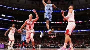 CHICAGO, ILLINOIS - APRIL 02: Ja Morant #12 of the Memphis Grizzlies soars in to dunk the ball as Alex Caruso #6 of the Chicago Bulls and Nikola Vucevic #9 defend in the second half on April 02, 2023 at United Center in Chicago, Illinois. Chicago defeated Memphis 128-107. NOTE TO USER: User expressly acknowledges and agrees that, by downloading and or using this photograph, User is consenting to the terms and conditions of the Getty Images License Agreement. (Photo by Jamie Sabau/Getty Images)