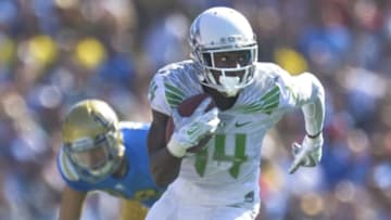Oct 11, 2014; Pasadena, CA, USA; Oregon Ducks defensive back Ifo Ekpre-Olomu (14) intercepts a pass intended for UCLA Bruins wide receiver Logan Sweet (L) during second half at Rose Bowl. Mandatory Credit: Robert Hanashiro-USA TODAY Sports