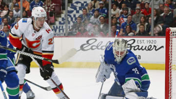 VANCOUVER, BC - OCTOBER 3: Sean Monahan #23 of the Calgary Flames looks on as Jacob Markstrom #25 of the Vancouver Canucks makes a save during their NHL game at Rogers Arena October 3, 2018 in Vancouver, British Columbia, Canada. (Photo by Jeff Vinnick/NHLI via Getty Images)