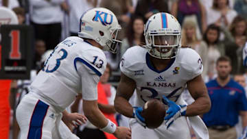 Nov 14, 2015; Fort Worth, TX, USA; Kansas Jayhawks quarterback Ryan Willis (13) hands off to Kansas Jayhawks running back Taylor Cox (36) during the first quarter against the TCU Horned Frogs at Amon G. Carter Stadium. Mandatory Credit: Jerome Miron-USA TODAY Sports