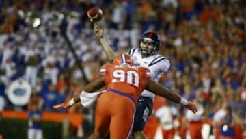 Oct 3, 2015; Gainesville, FL, USA; Mississippi Rebels quarterback Chad Kelly (10) throws the ball as Florida Gators defensive lineman Jonathan Bullard (90) pressures during the first half at Ben Hill Griffin Stadium. Mandatory Credit: Kim Klement-USA TODAY Sports