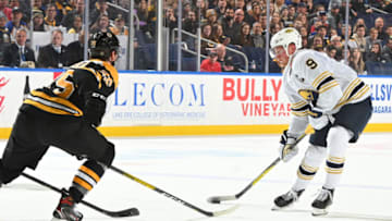 BUFFALO, NY - DECEMBER 27: Jack Eichel #9 of the Buffalo Sabres controls the puck against Brandon Carlo #25 of the Boston Bruins during an NHL game on December 27, 2019 at KeyBank Center in Buffalo, New York. Boston won 3-0. (Photo by Joe Hrycych/NHLI via Getty Images)