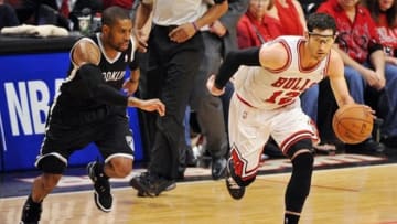 Apr 27, 2013; Chicago, IL, USA; Chicago Bulls shooting guard Kirk Hinrich (12) moves the ball past Brooklyn Nets point guard C.J. Watson (1) in triple overtime during game four of the first round of the 2013 NBA playoffs at the United Center. The Bulls beat the Nets 142-134 in triple overtime. Mandatory Credit: Rob Grabowski-USA TODAY Sports