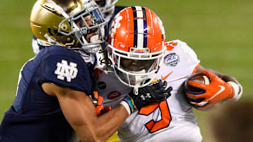 Dec 19, 2020; Charlotte, NC, USA; Clemson Tigers running back Travis Etienne (9) is tackled by Notre Dame Fighting Irish cornerback Nick McCloud (4) in the third quarter at Bank of America Stadium. Mandatory Credit: Bob Donnan-USA TODAY Sports
