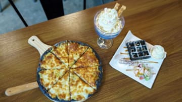 This photo taken on January 24, 2018 shows various dishes including durian flavoured ice cream, waffles and pizza at Mao Shan Wang cafe in the Chinatown district of Singapore.The Singapore eatery centred around the pungent tropical fruit durian has caught a whiff of success as patrons flock to the cafe in droves for a bite of its exotic offerings. / AFP PHOTO / Nicholas YEO (Photo credit should read NICHOLAS YEO/AFP/Getty Images)