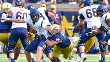 Sep 11, 2021; South Bend, Indiana, USA; Toledo Rockets quarterback Carter Bradley (2) loses the ball as he his hit by Notre Dame Fighting Irish defensive lineman Myron Tagovailoa-Amosa (95) in the fourth quarter at Notre Dame Stadium. Mandatory Credit: Matt Cashore-USA TODAY Sports
