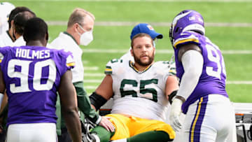 MINNEAPOLIS, MINNESOTA - SEPTEMBER 13: Ifeadi Odenigbo #95 of the Minnesota Vikings speaks to Lane Taylor #65 of the Green Bay Packers after Taylor was injured on a play during the fourth quarter of the game at U.S. Bank Stadium on September 13, 2020 in Minneapolis, Minnesota. The Packers defeated the Vikings 43-34. (Photo by Hannah Foslien/Getty Images)