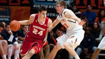 Feb 4, 2014; Champaign, IL, USA; Wisconsin Badgers guard Bronson Koenig (24) dribbles around Illinois Fighting Illini forward Jon Ekey (33) during the first half at State Farm Center. Mandatory Credit: Bradley Leeb-USA TODAY Sports