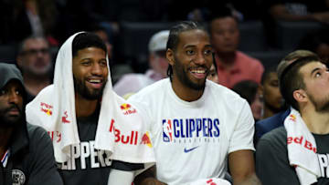 LOS ANGELES, CALIFORNIA - DECEMBER 17: Paul George #13 and Kawhi Leonard #2 of the LA Clippers laugh on the bench during a 120-99 win over the Phoenix Suns at Staples Center on December 17, 2019 in Los Angeles, California. (Photo by Harry How/Getty Images)