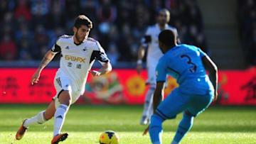 SWANSEA, WALES - JANUARY 19: Swansea player Alejandro Pozuelo (l) runs at Danny Rose during the Barclays premier league match between Swansea City and Tottenham Hotspur at Liberty Stadium on January 19, 2014 in Swansea, Wales. (Photo by Stu Forster/Getty Images)