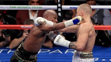 LAS VEGAS, NV - AUGUST 26: (L-R) Floyd Mayweather Jr. throws a punch at Conor McGregor during their super welterweight boxing match on August 26, 2017 at T-Mobile Arena in Las Vegas, Nevada. (Photo by Sean M. Haffey/Getty Images)