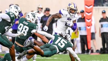 Washington's Ja'Lynn Polk, right, runs past Michigan State defenders on his way to a touchdown during the second quarter on Saturday, Sept. 16, 2023, at Spartan Stadium in East Lansing.
