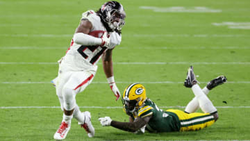 GREEN BAY, WISCONSIN - OCTOBER 05: Todd Gurley II #21 of the Atlanta Falcons carries the ball as Josh Jackson #37 of the Green Bay Packers attempts to make the tackle during the second half at Lambeau Field on October 05, 2020 in Green Bay, Wisconsin. (Photo by Dylan Buell/Getty Images)