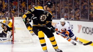 Sep 30, 2014; Boston, MA, USA; Boston Bruins defenseman Zdeno Chara (33) tries to control the puck in front of New York Islanders left wing Cory Conacher (89) during the second period at TD Garden. Mandatory Credit: Winslow Townson-USA TODAY Sports