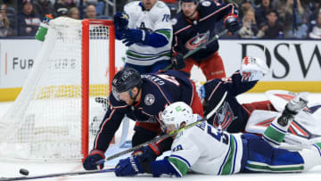 Nov 26, 2021; Columbus, Ohio, USA; Columbus Blue Jackets defenseman Vladislav Gavrikov (44) dives for the puck against Vancouver Canucks center Bo Horvat (53) in the third period at Nationwide Arena. Mandatory Credit: Aaron Doster-USA TODAY Sports