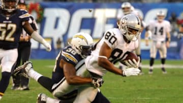 Dec 22, 2013; San Diego, CA, USA; Oakland Raiders receiver Rod Streater (80) is tackled by San Diego Chargers safety Marcus Gilchrist (38) at Qualcomm Stadium. Mandatory Credit: Kirby Lee-USA TODAY Sports