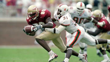 9 Oct 1999: Ron Dugans #80 of the Florida State Seminoles carries the ball as he is tackled by Phillip Buchanan #31of the Miami Hurricanes at the Doak Campbell Stadium in Tallahassee, Florida. The Seminoles defeated the Hurricanes 31-21. Mandatory Credit: Andy Lyons /Allsport