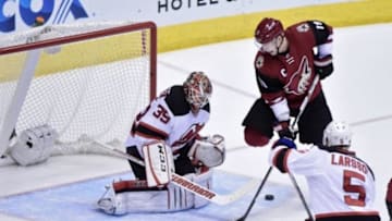 Jan 16, 2016; Glendale, AZ, USA; New Jersey Devils goalie Cory Schneider (35) makes a save on Arizona Coyotes right wing Shane Doan (19) as defenseman Adam Larsson (5) defends during the second period at Gila River Arena. Mandatory Credit: Matt Kartozian-USA TODAY Sports