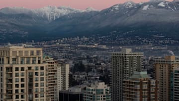 BURNABY, BRITISH COLUMBIA - DECEMBER 22: A view of metro Vancouver skyline at sunrise against the two pointed peaks aka "The Lions" on December 22, 2020 in Burnaby, British Columbia, Canada. The Provincial Health Officer (PHO) has ordered that events and gatherings be suspended in order to reduce the transmission of COVID-19 through social contact and travel. The order lasts from November 19, 2020 at midnight to January 8, 2021 at midnight. (Photo by Andrew Chin/Getty Images)