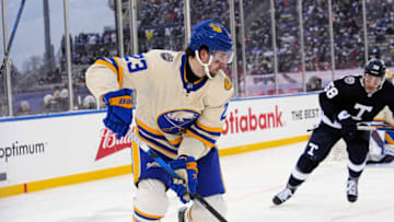 Mar 13, 2022; Hamilton, Ontario, CAN; Buffalo Sabres defenseman Mattias Samuelsson (23) carries the puck past Toronto Maple Leafs forward Michael Bunting (58) during the third period in the 2022 Heritage Classic ice hockey game at Tim Hortons Field. Mandatory Credit: John E. Sokolowski-USA TODAY Sports