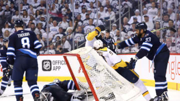 WINNIPEG, MB - MAY 1: Dustin Byfuglien #33 of the Winnipeg Jets checks Filip Forsberg #9 of the Nashville Predators into the net as goaltender Connor Hellebuyck #37 makes a save during second period action in Game Three of the Western Conference Second Round during the 2018 NHL Stanley Cup Playoffs at the Bell MTS Place on May 1, 2018 in Winnipeg, Manitoba, Canada. (Photo by Darcy Finley/NHLI via Getty Images)