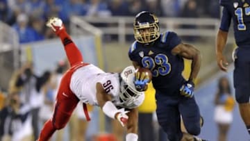Nov 3, 2012; Pasadena, CA, USA; UCLA Bruins running back Jonathan Franklin (23) runs past the outstretched arms of Arizona Wildcats defensive lineman Willie Mobley (96) during the first quarter at the Rose Bowl. Mandatory Credit: Andrew Fielding-USA TODAY Sports