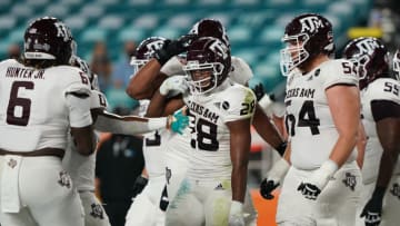 Jan 2, 2021; Miami Gardens, FL, USA; Texas A&M Aggies running back Isaiah Spiller (28) is congratulated during the first half against the North Carolina Tar Heels at Hard Rock Stadium. Mandatory Credit: Jasen Vinlove-USA TODAY Sports
