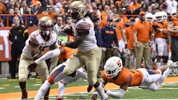 Nov 19, 2016; Syracuse, NY, USA; Florida State Seminoles running back Dalvin Cook (4) scores a rushing touchdown as Syracuse Orange defensive back Daivon Ellison (19) dives in an attempt to make a tackle during the third quarter of a game at the Carrier Dome. Florida State won 45-14. Mandatory Credit: Mark Konezny-USA TODAY Sports