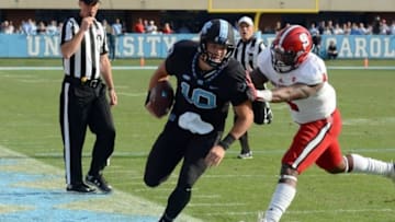 Nov 25, 2016; Chapel Hill, NC, USA; North Carolina Tar Heels quarterback Mitch Trubisky (10) is pushed out of bounds by North Carolina State Wolfpack linebacker Jarod Fernandez (4) during the second half at Kenan Memorial Stadium. The Wolfpack won 28-21. Mandatory Credit: Rob Kinnan-USA TODAY Sports