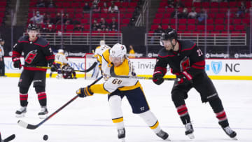 Mar 11, 2021; Raleigh, North Carolina, USA; Nashville Predators center Mikael Granlund (64) skates with the puck past Carolina Hurricanes defenseman Brett Pesce (22) at PNC Arena. Mandatory Credit: James Guillory-USA TODAY Sports