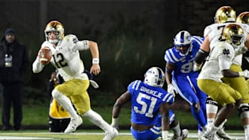 DURHAM, NORTH CAROLINA - NOVEMBER 09: Ian Book #12 of the Notre Dame Fighting Irish sprints away from the Duke Blue Devils defense during the second half of their game at Wallace Wade Stadium on November 09, 2019 in Durham, North Carolina. (Photo by Grant Halverson/Getty Images)